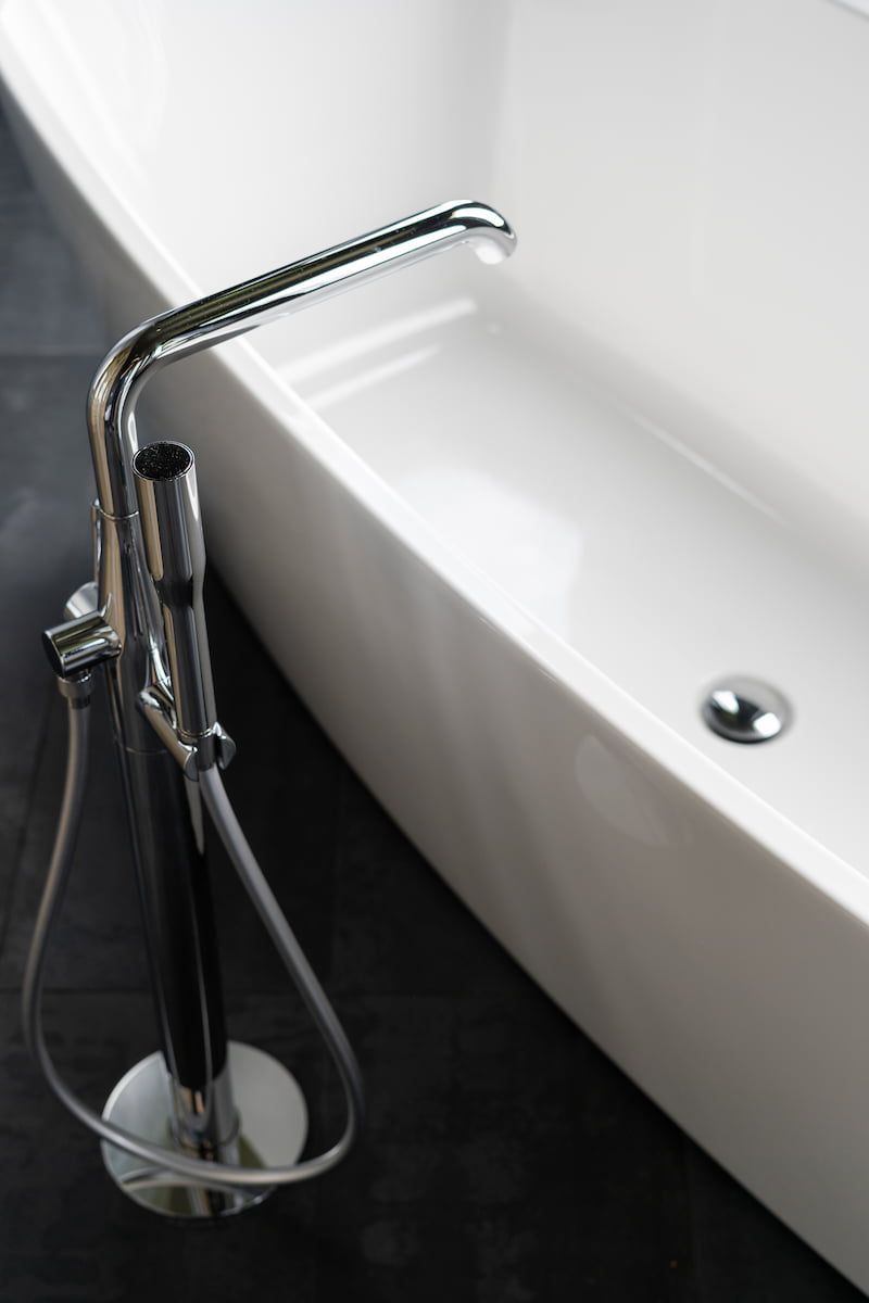 Ein silberner Wasserhahn mit einer weißen Badewanne